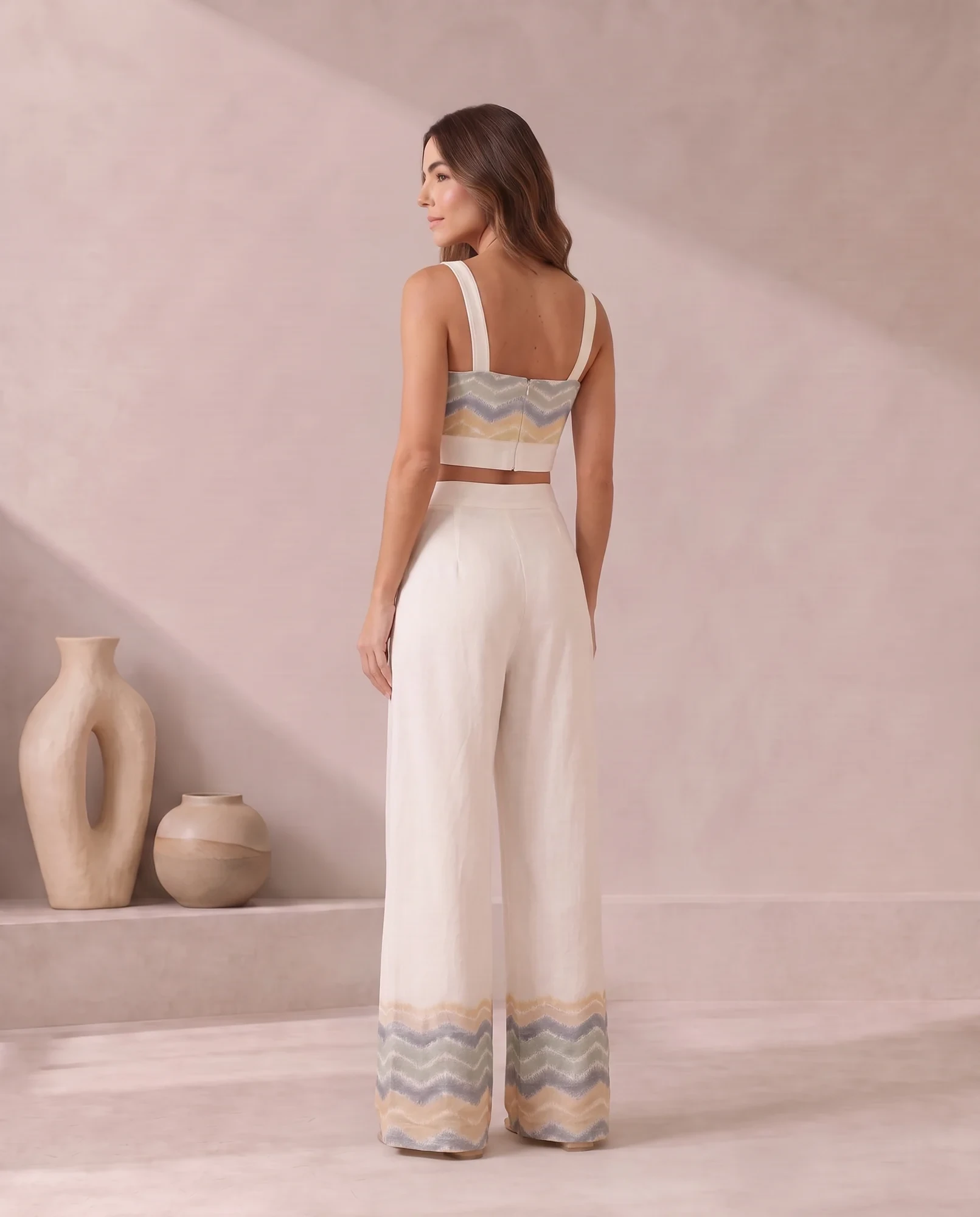 Back three-quarter view of the ivory bandeau crop top and wide-leg trousers