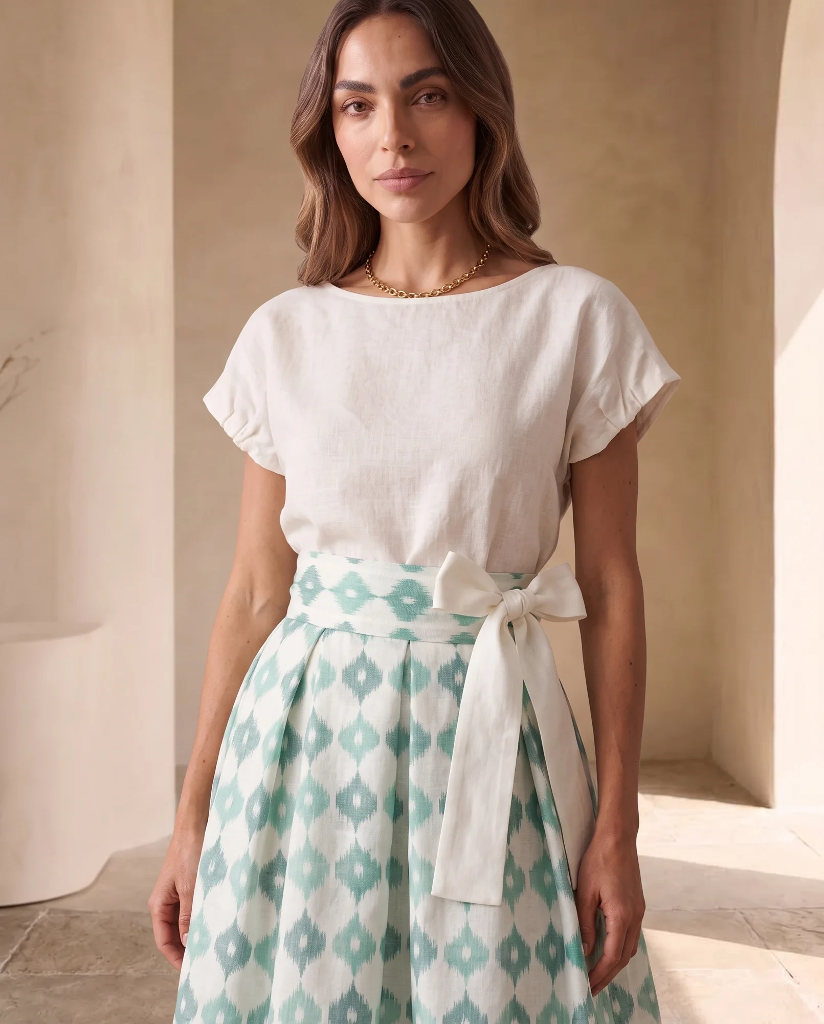 Close-up of the wide ikat waistband and ivory tie sash on the mint midi skirt